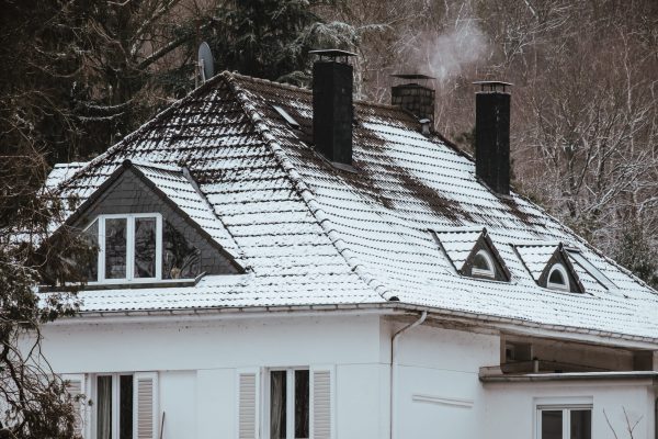 A big house with the roof covered by snow in winter