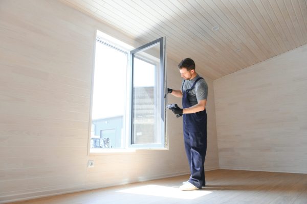 The worker installing and checking window in the house